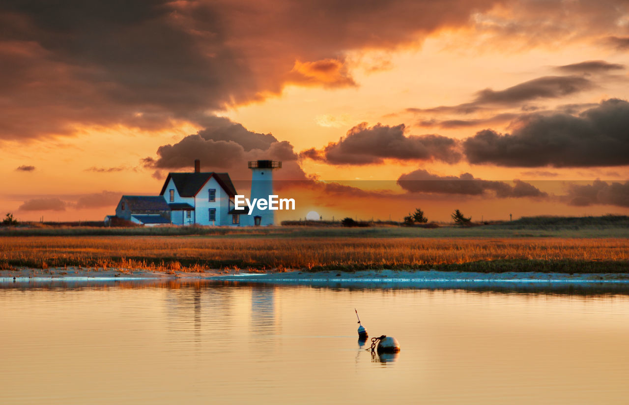water, sky, reflection, cloud, sunset, horizon, dawn, architecture, sea, built structure, nature, evening, building exterior, beauty in nature, building, shore, scenics - nature, travel destinations, landscape, land, environment, orange color, ocean, afterglow, animal themes, animal, tranquility, outdoors, beach, house, dramatic sky, travel, no people, coast, sun, tranquil scene, lighthouse, sunlight