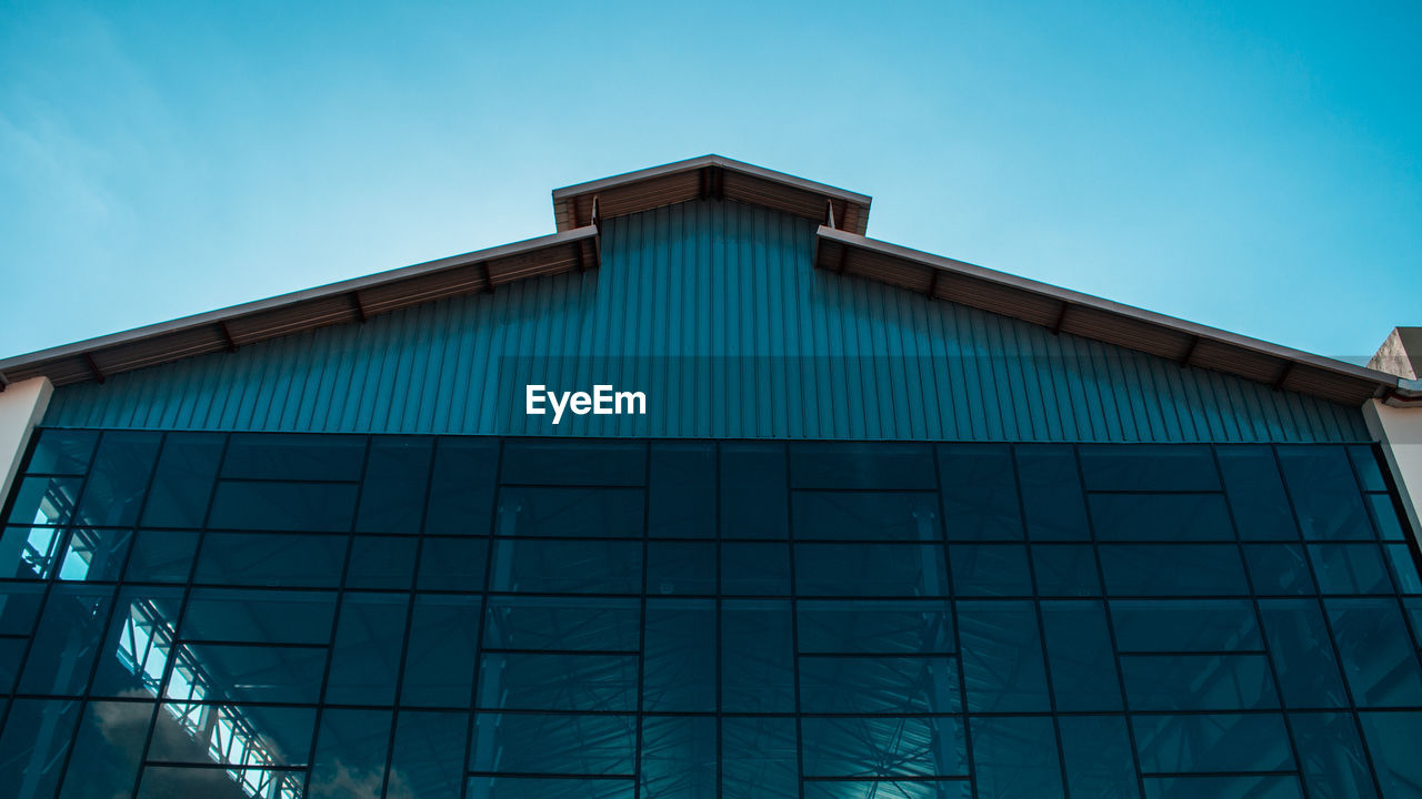 Low angle view of modern building against clear blue sky