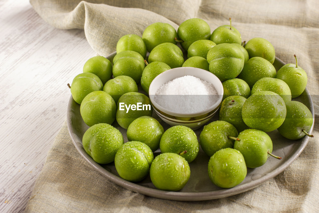 Unripe sour green plums with salt. traditional turkish snack.