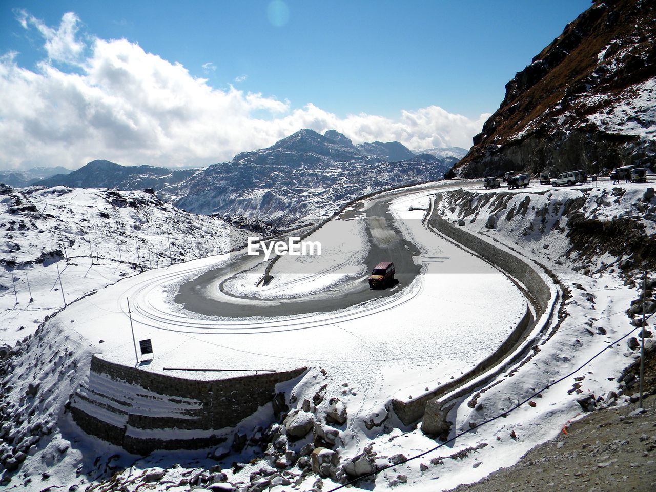Snow covered road by mountains against sky at barnila pass sikkim
