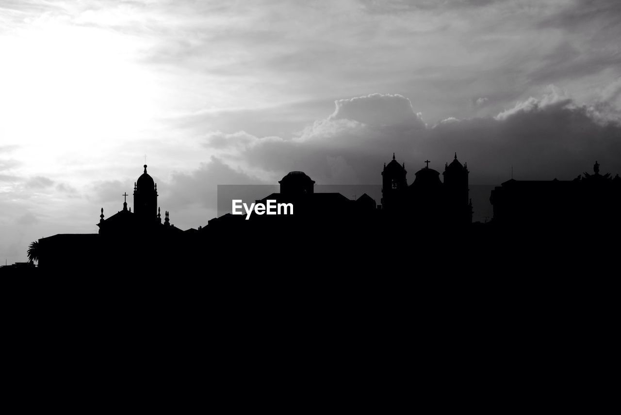 Silhouette church against cloudy sky