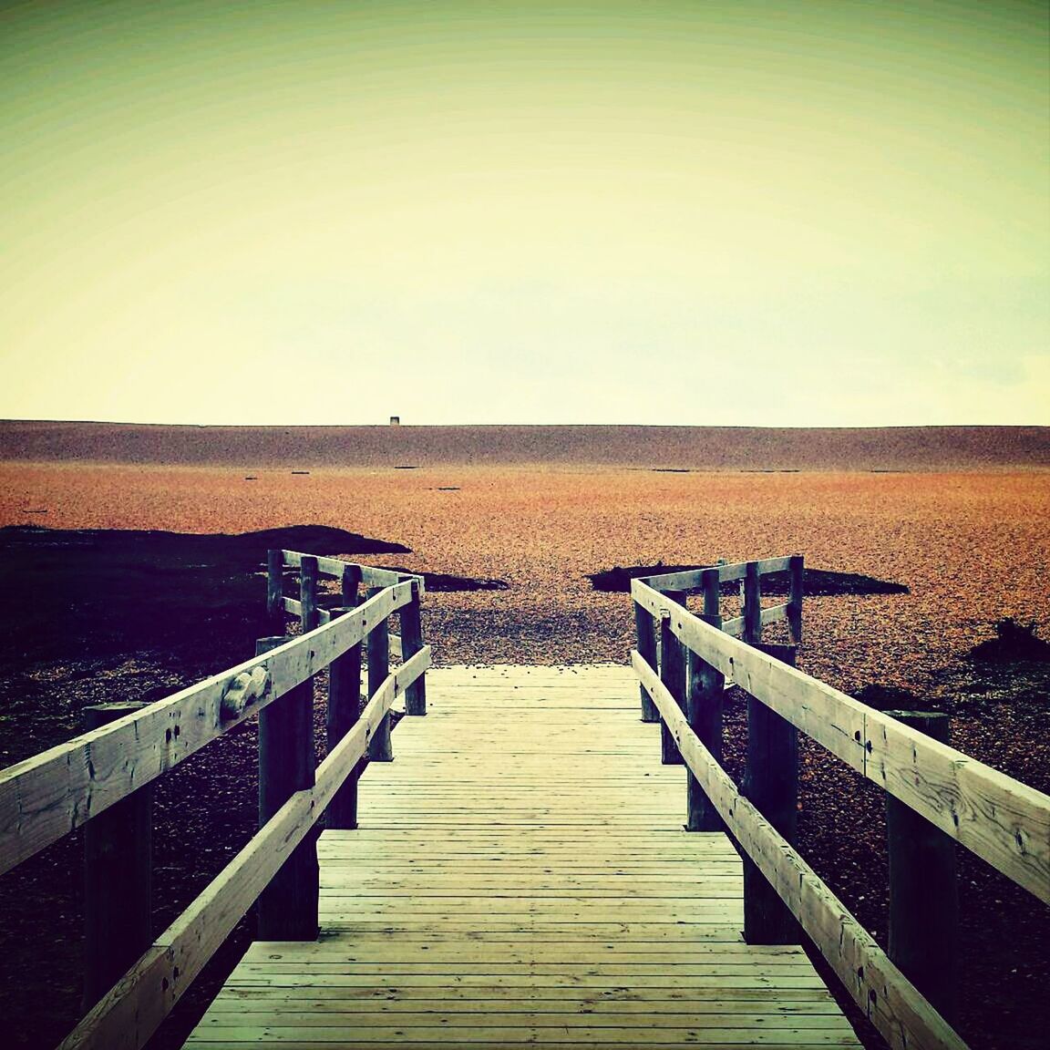 Staircase leading towards landscape against clear sky