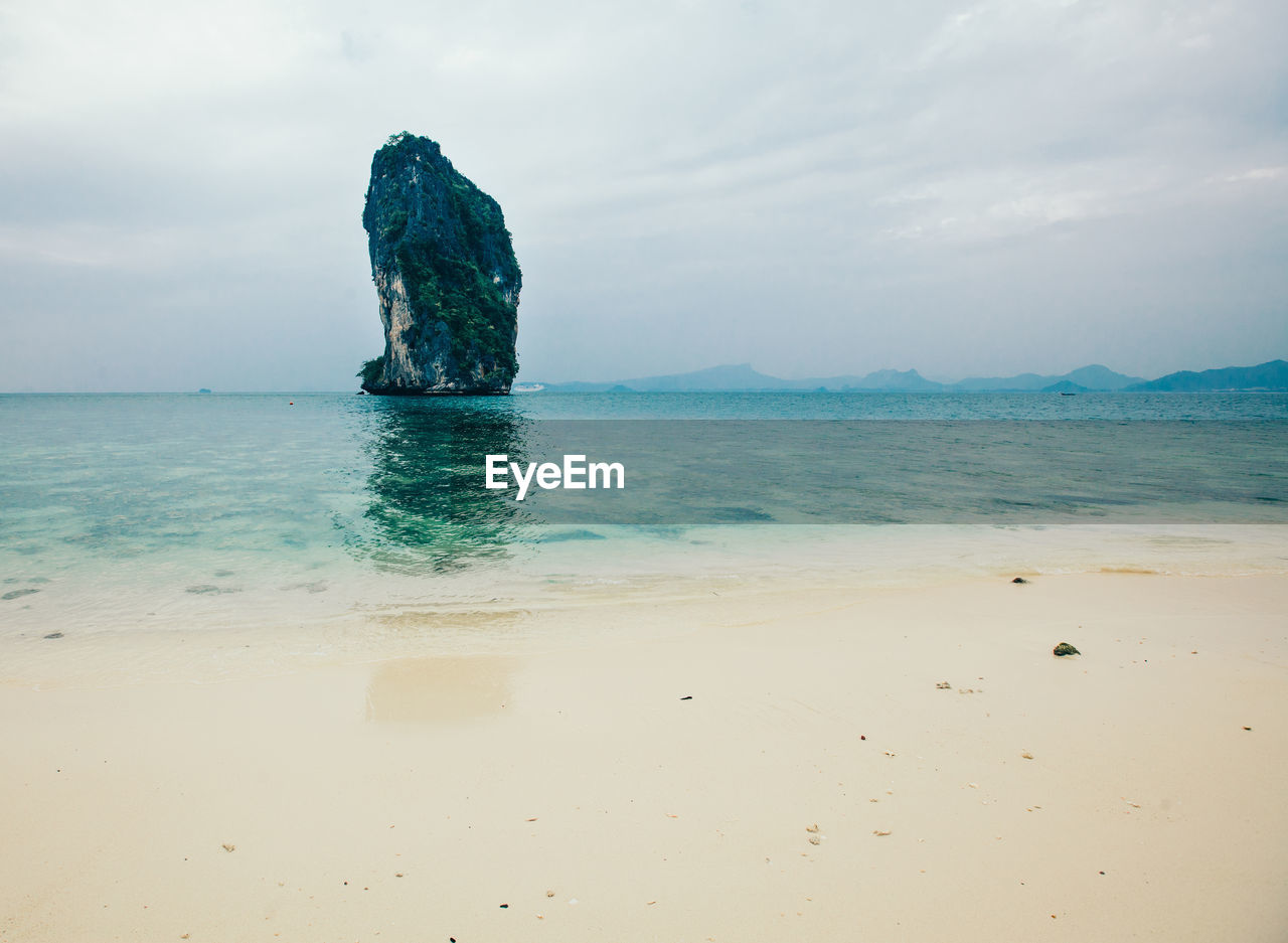 Scenic view of rock formation by sea against sky