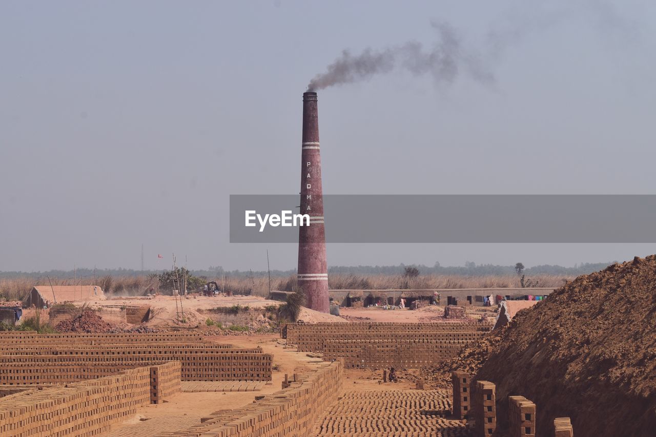 FACTORY ON FIELD AGAINST SKY