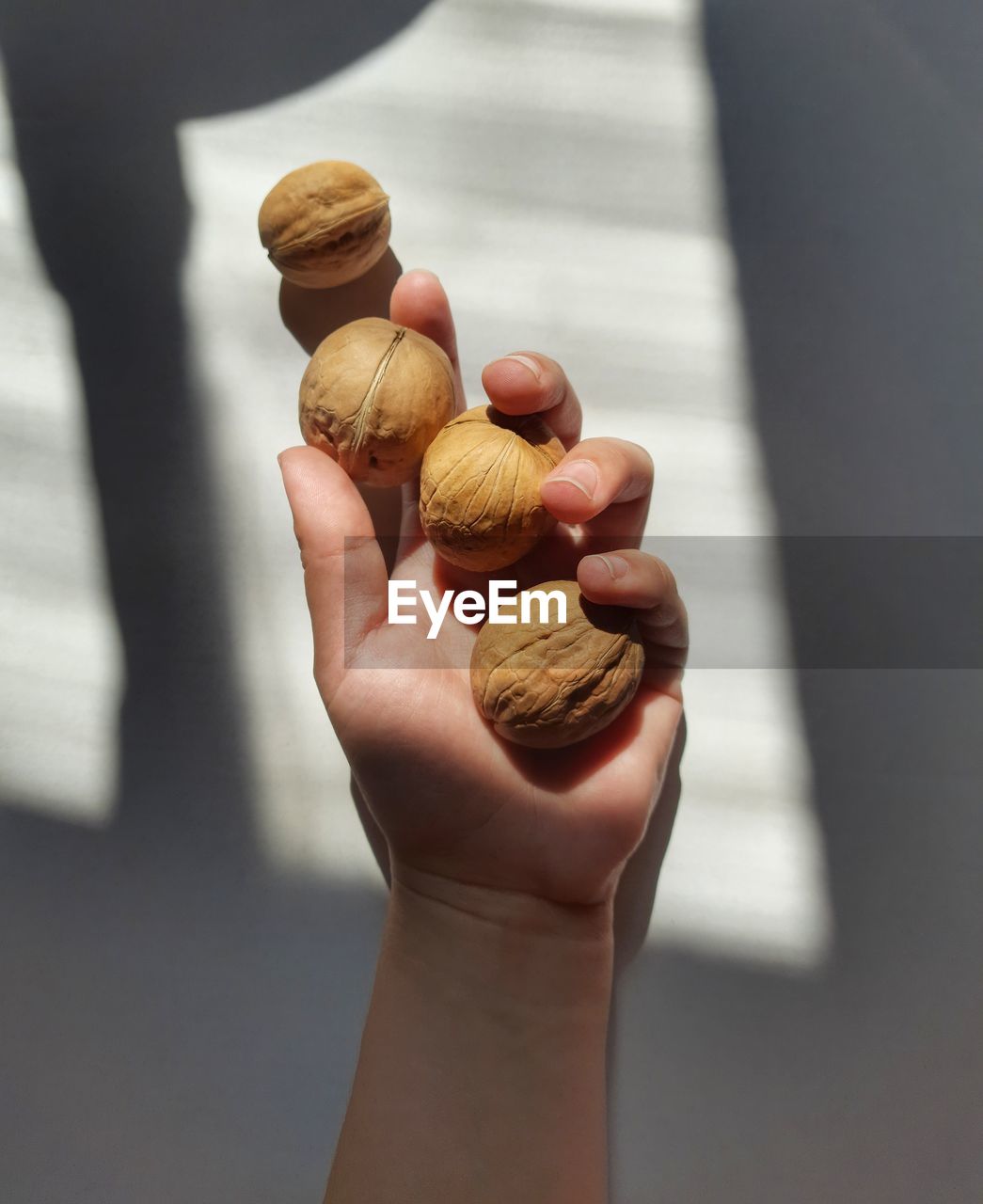 CLOSE-UP OF PERSON HOLDING ICE CREAM CONE ON TABLE