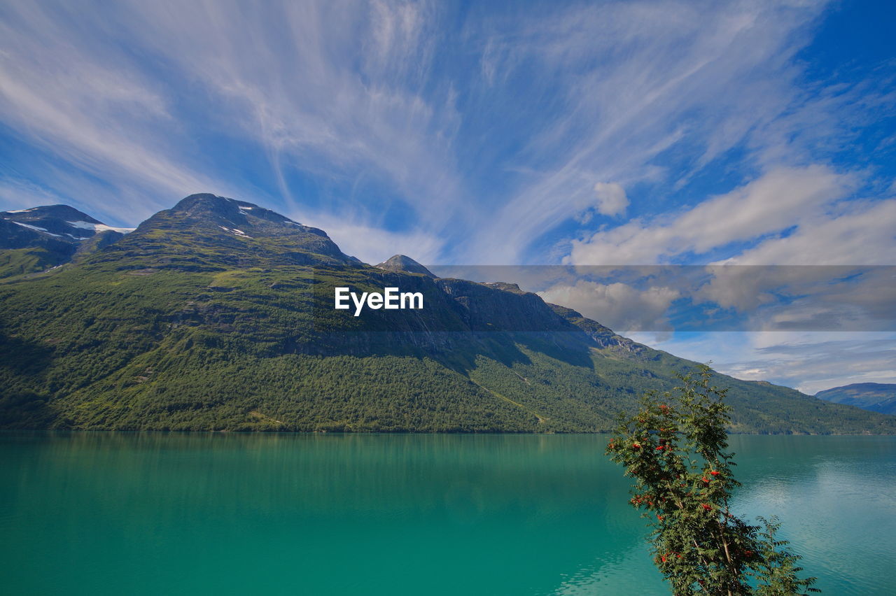 Scenic view of lake by mountains against sky