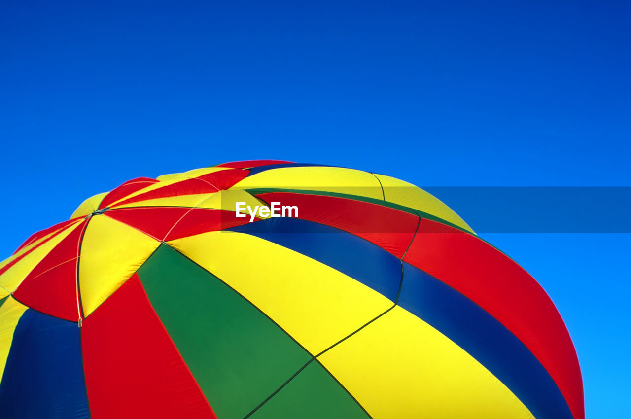 Close-up of hot air balloon against clear blue sky