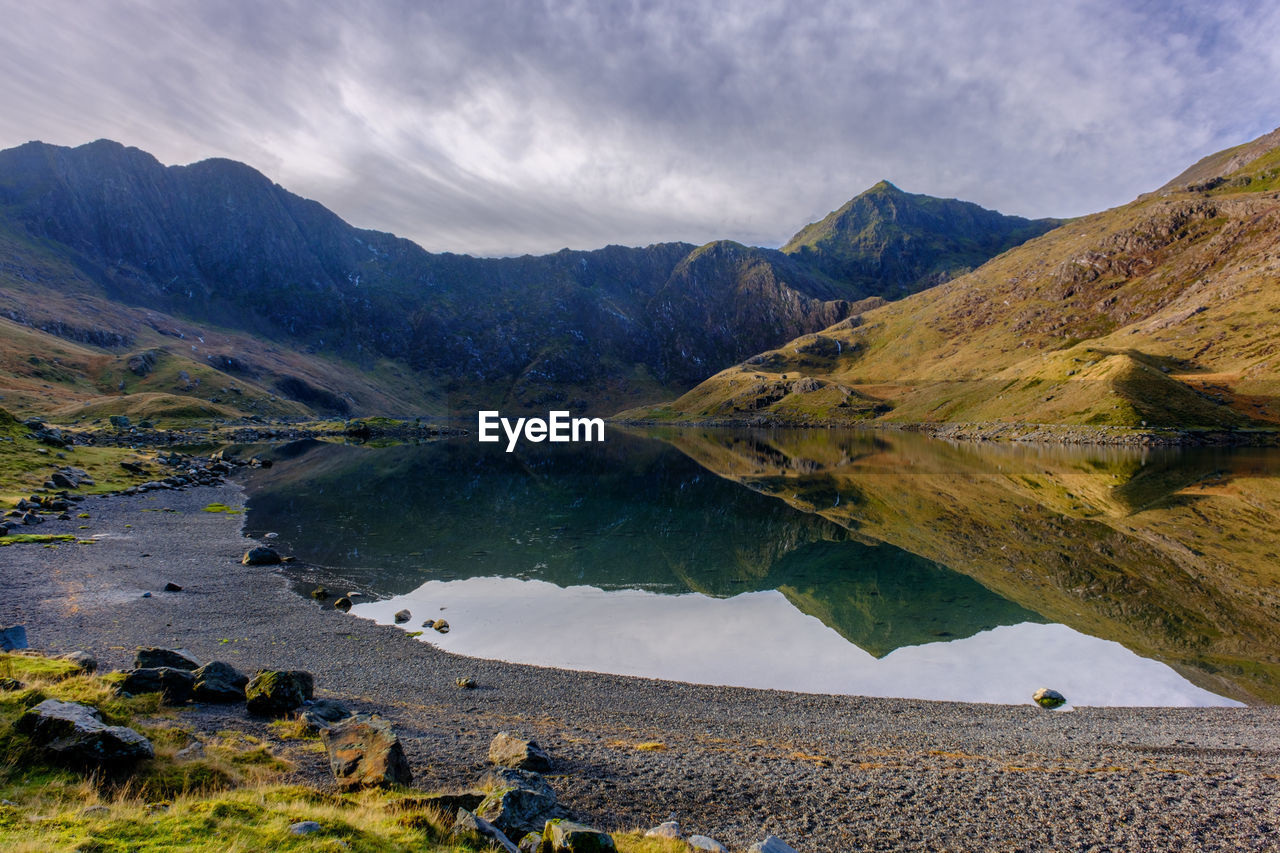 The summit of snowdon reflected in a lake in snowdonia national park, north wales