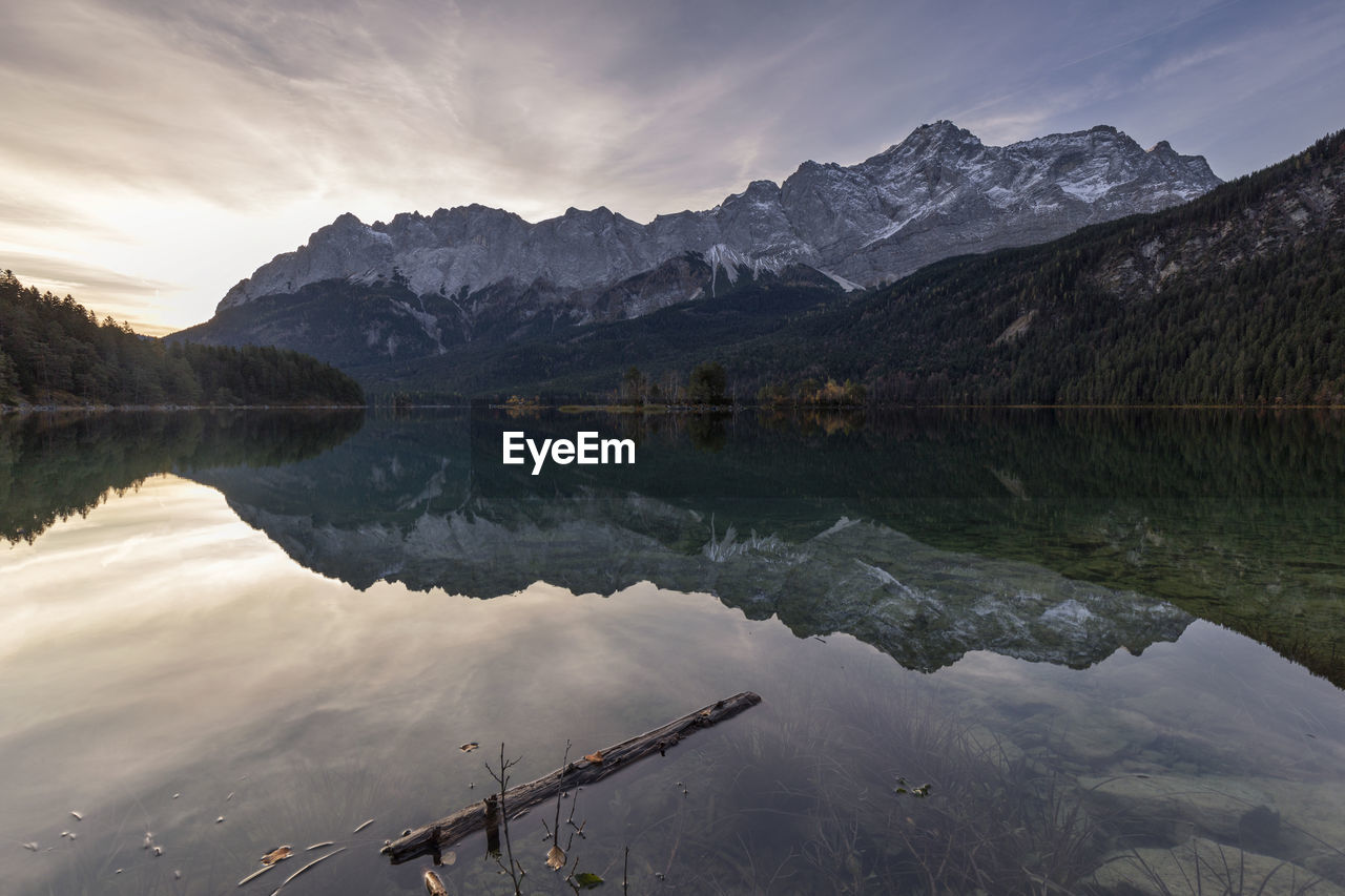 Scenic view of lake by mountains against sky