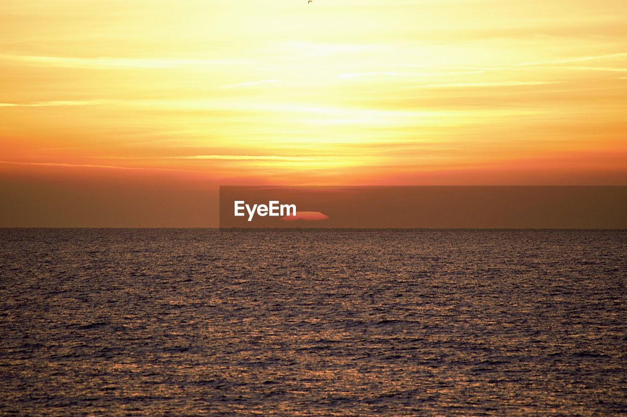 sunset, sky, horizon, beauty in nature, sea, scenics - nature, water, sun, tranquility, orange color, horizon over water, nature, afterglow, tranquil scene, ocean, sunlight, dawn, idyllic, dramatic sky, cloud, evening, coast, environment, no people, shore, land, outdoors, beach, urban skyline, seascape, landscape, travel, silhouette, romantic sky, travel destinations, red sky at morning, yellow, non-urban scene, atmospheric mood, flying, sunbeam, multi colored, moody sky, gold, transportation
