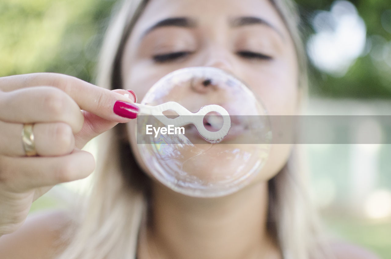 Close-up of woman blowing bubble