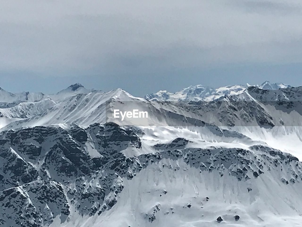 SNOW COVERED MOUNTAINS AGAINST SKY