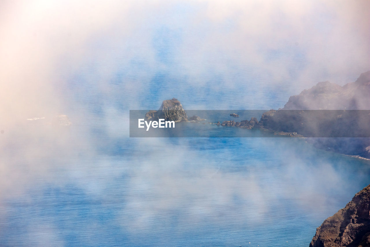 AERIAL VIEW OF SEA AND ROCKS AGAINST SKY