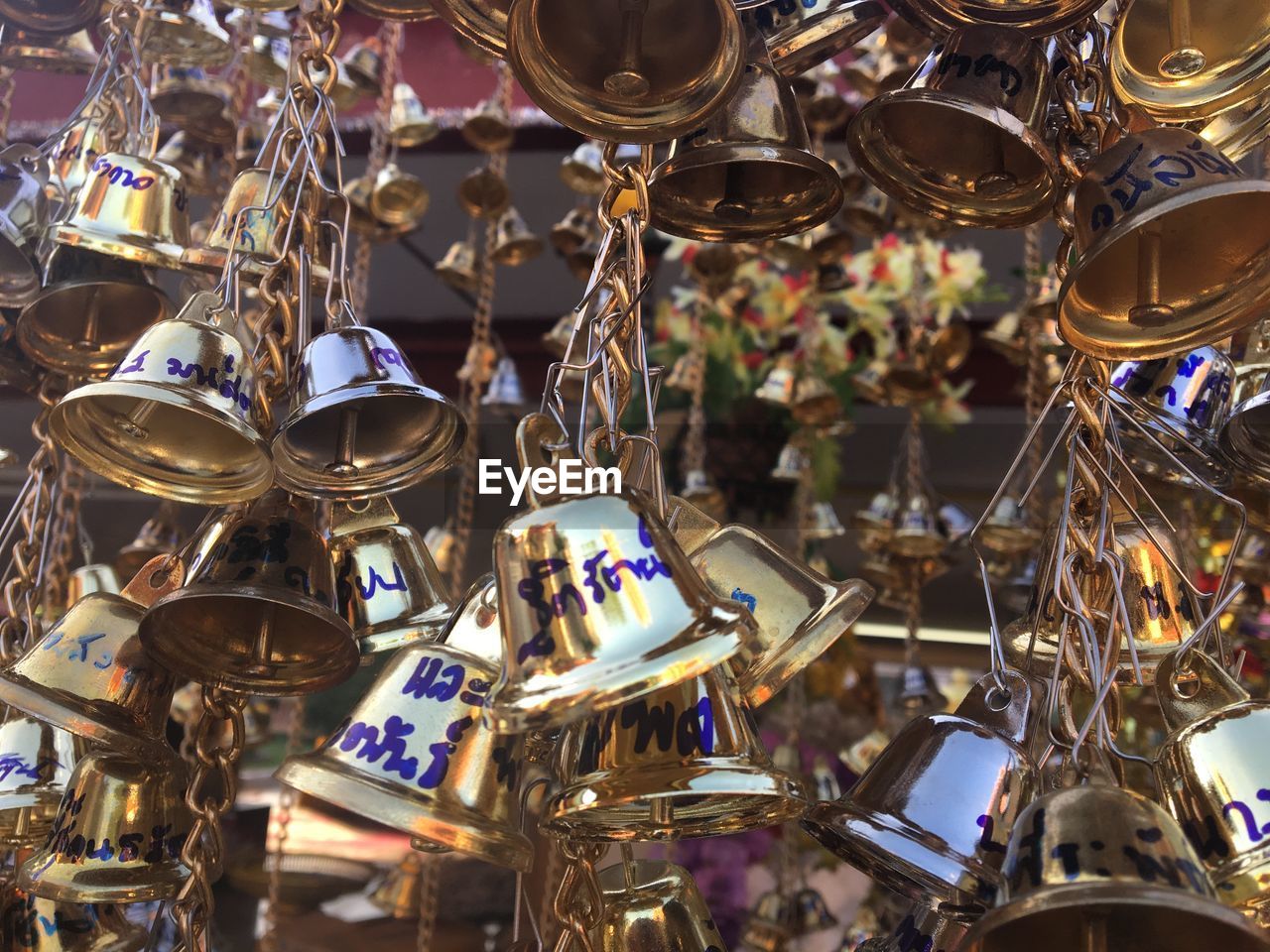 Close-up of golden bells hanging for sale in market