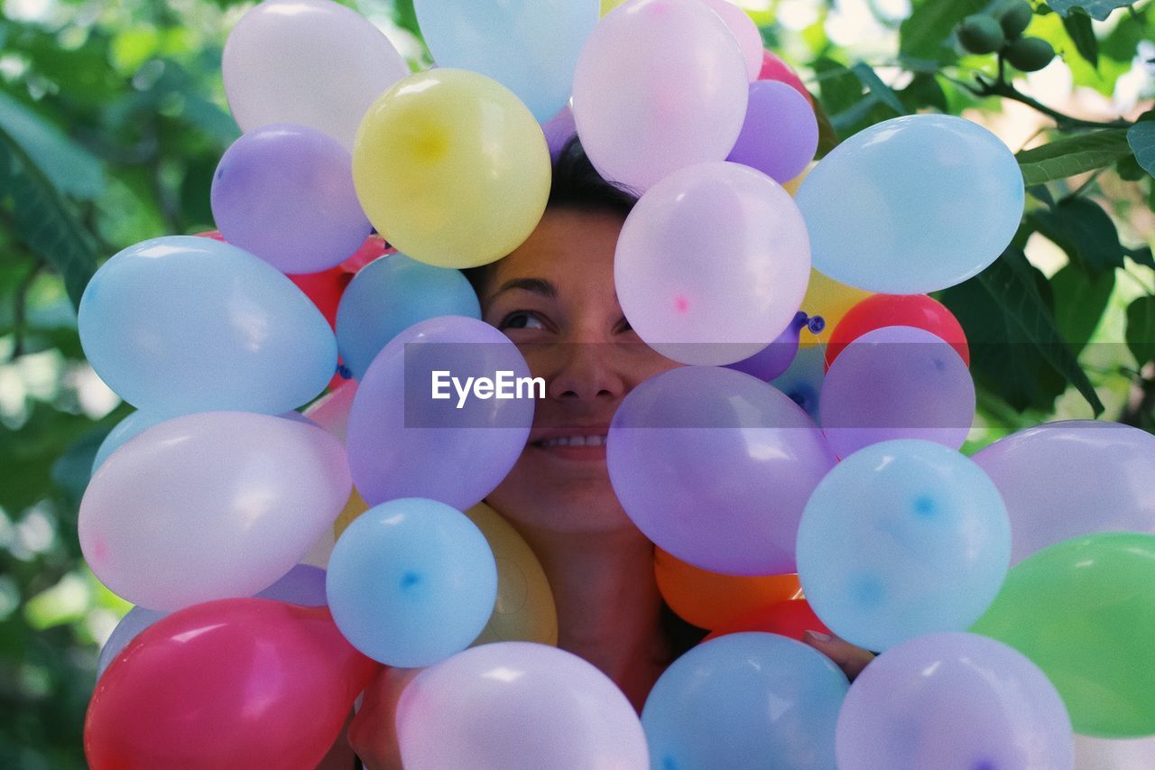 Close-up of woman amidst multi colored balloons
