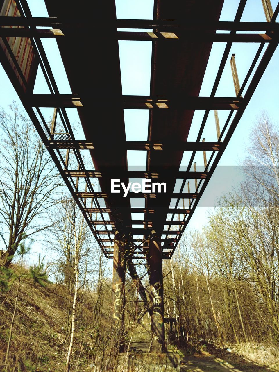 Incomplete bridge over field against sky