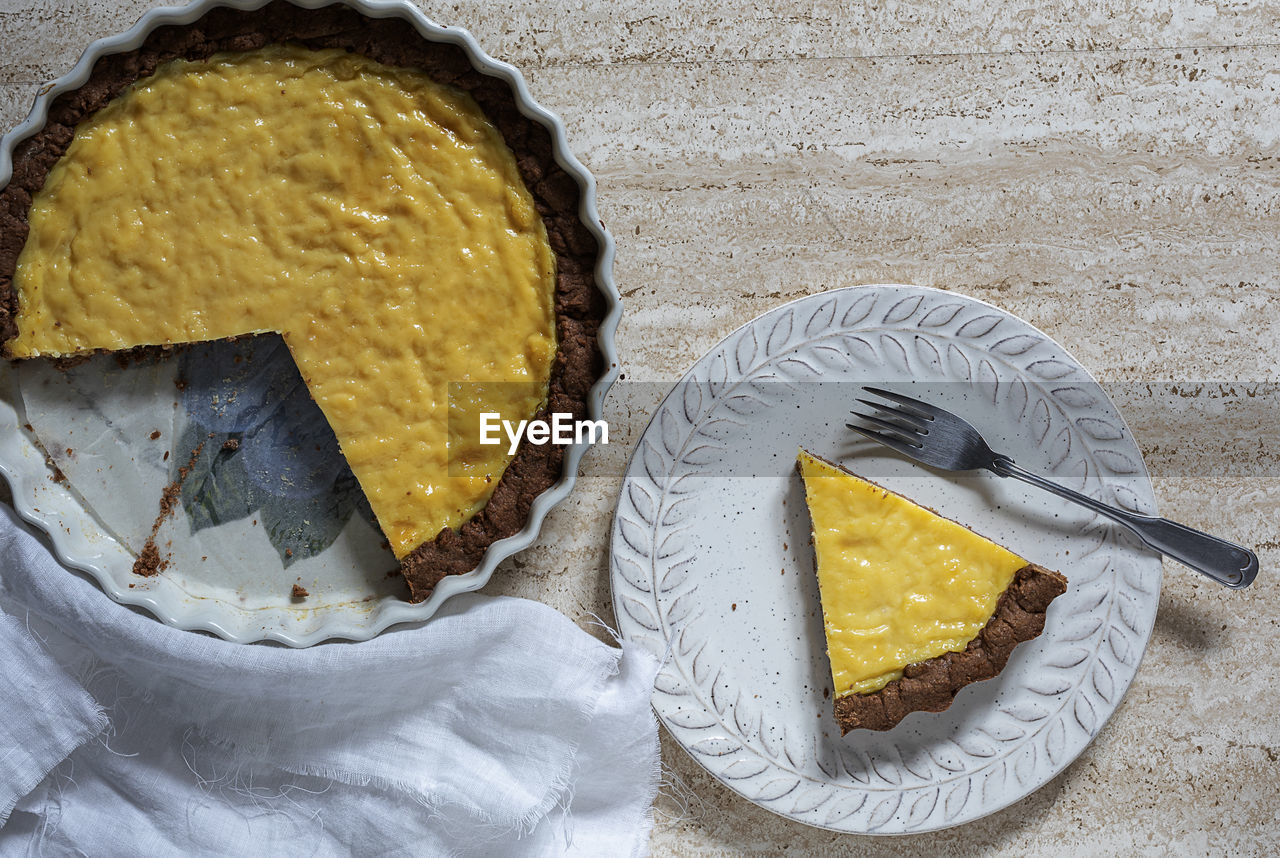 Slice of yellow shortcrust pastry tart with chocolate.