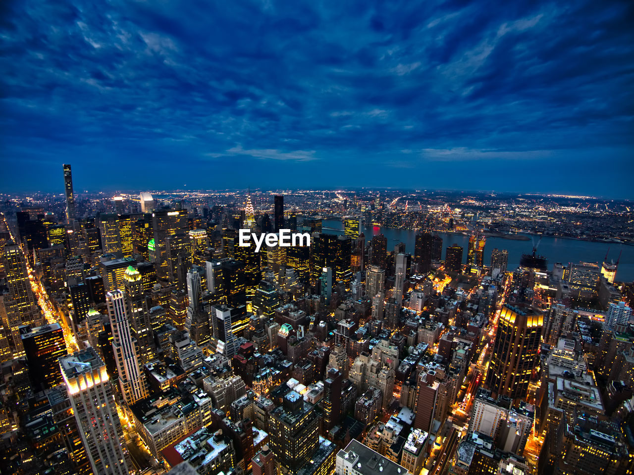 High angle view of illuminated city against sky at night