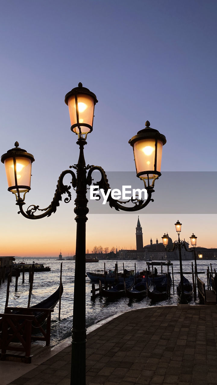 Low angle view of street light and gondolas in venice