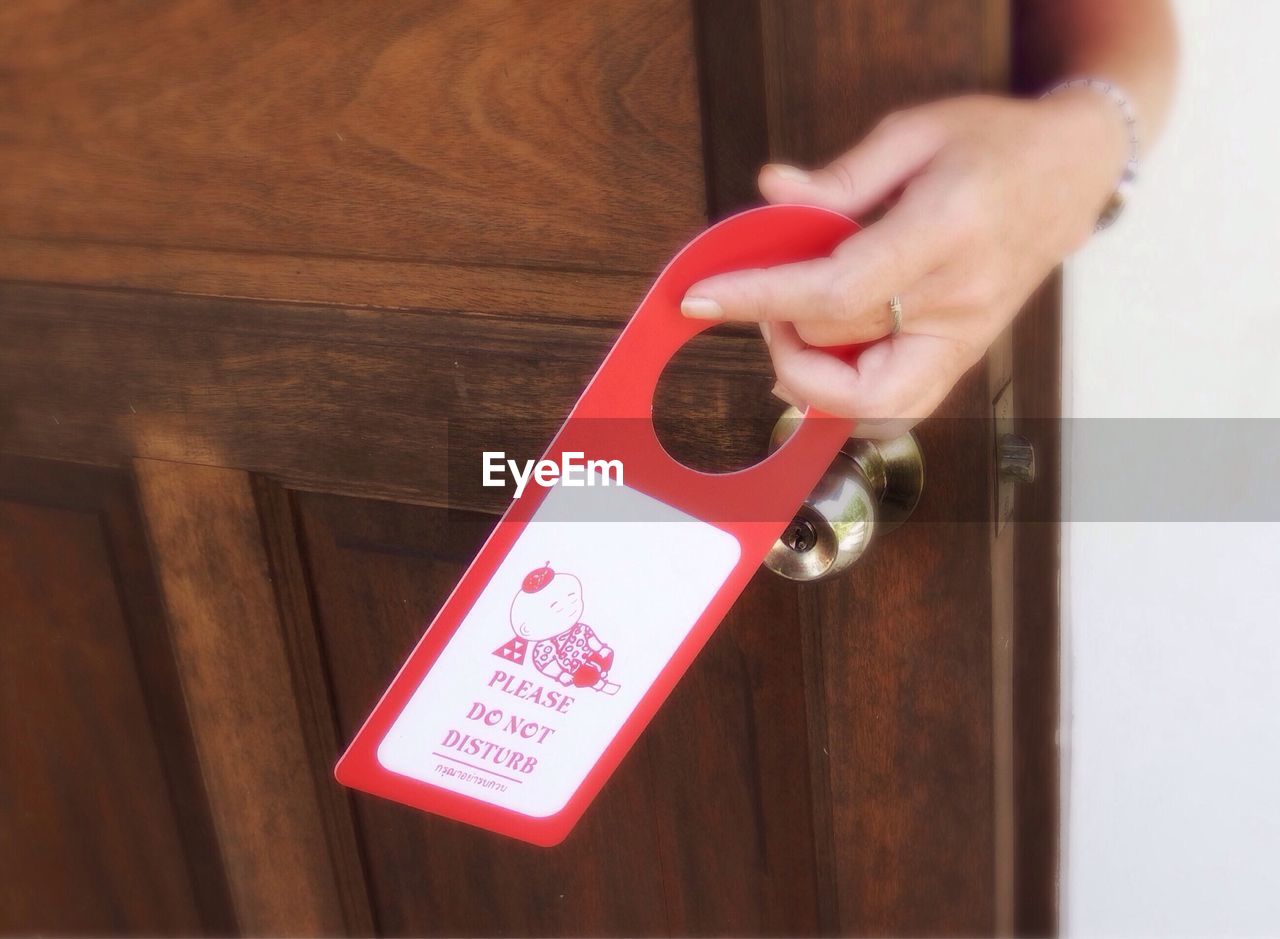 CLOSE-UP OF HAND WITH TEXT ON DOOR