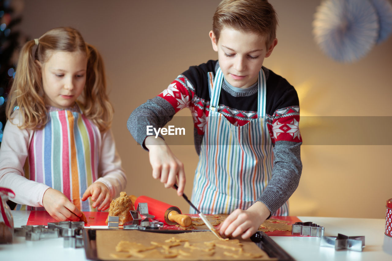 Siblings preparing cookies at home