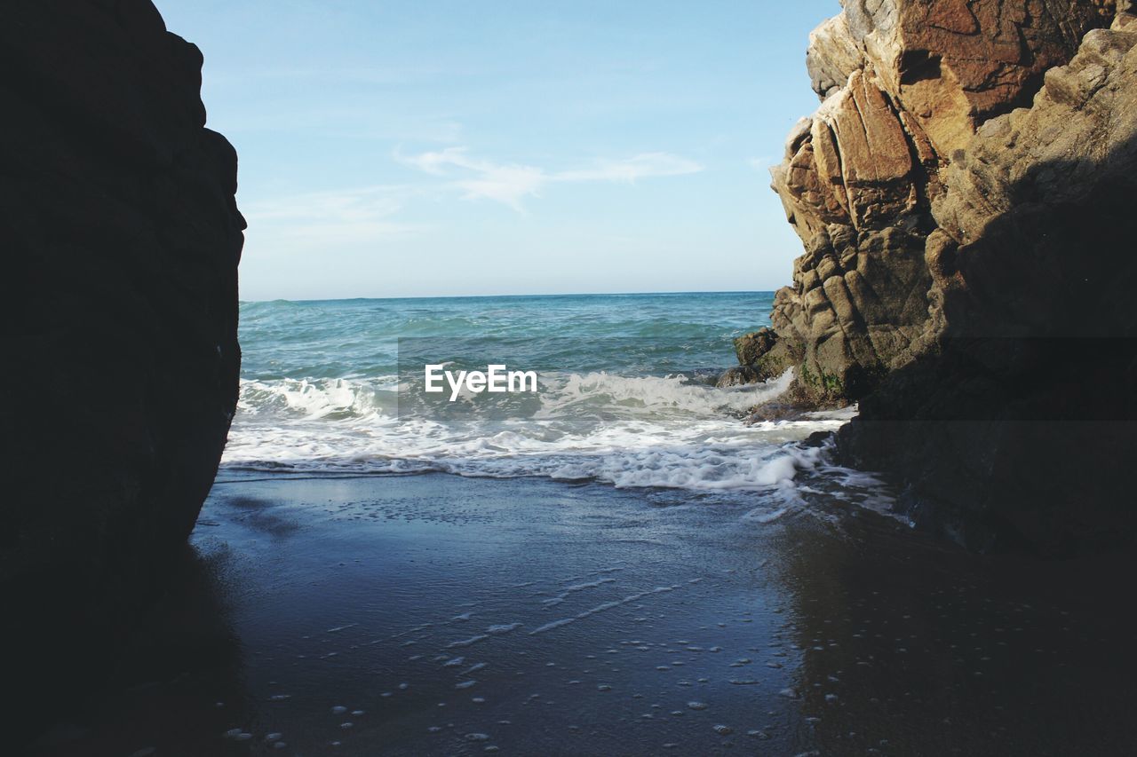 ROCK FORMATIONS IN SEA AGAINST SKY