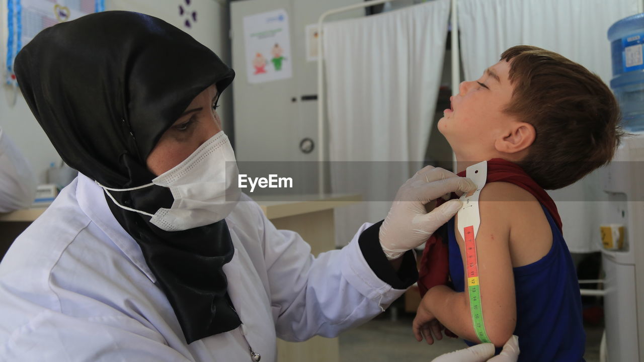 side view of doctor examining patient at clinic