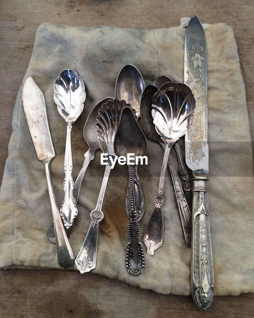 High angle view of spoon and table knife on fabric at table
