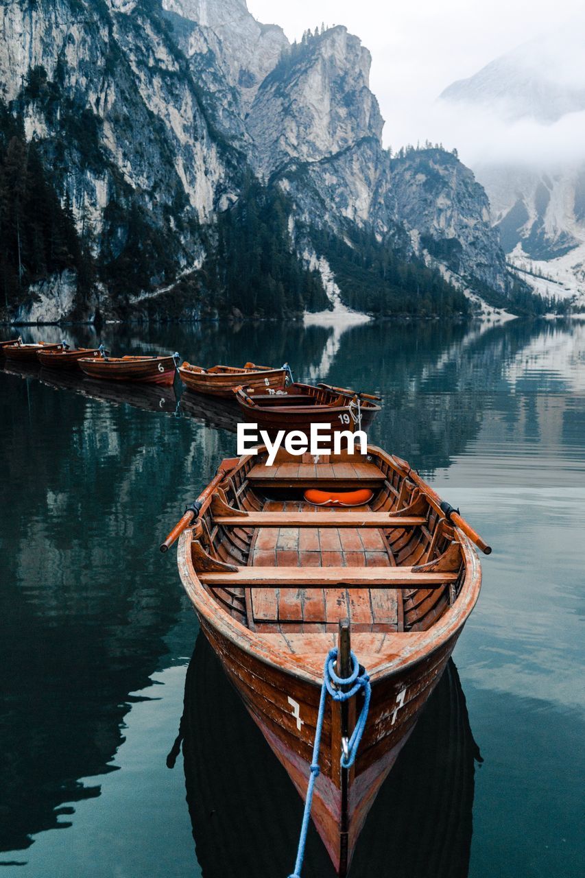 Boat moored on lake against mountains