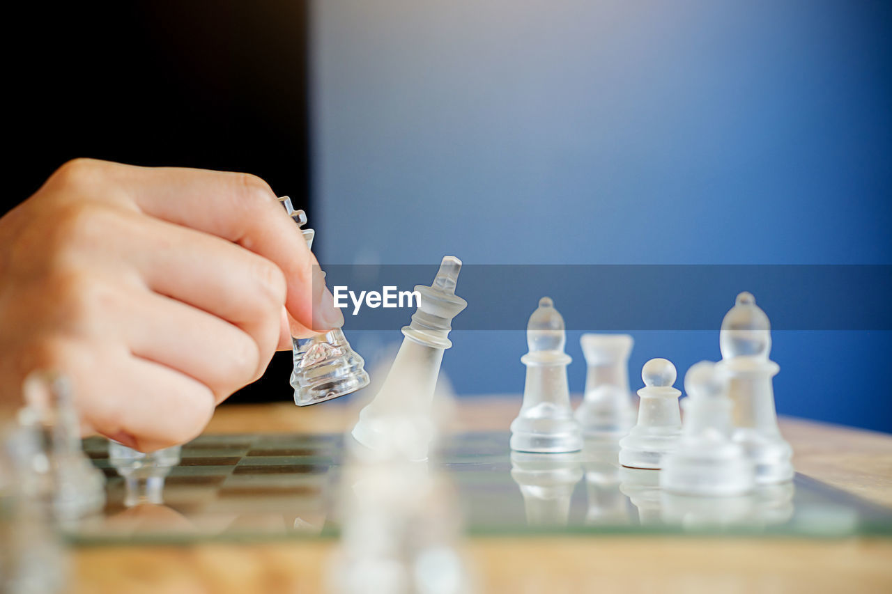 Cropped hand of person playing chess at home