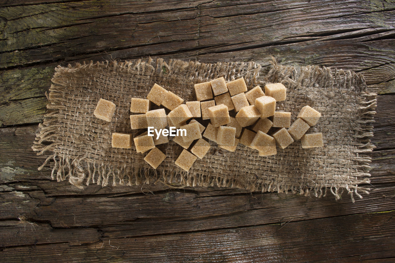 High angle view of sweet food on sack over wooden table