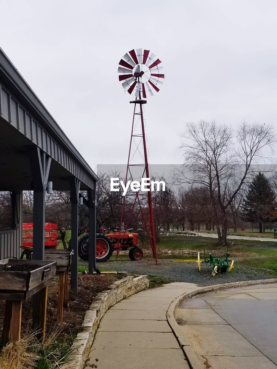 FERRIS WHEEL BY RAILROAD TRACK AGAINST SKY