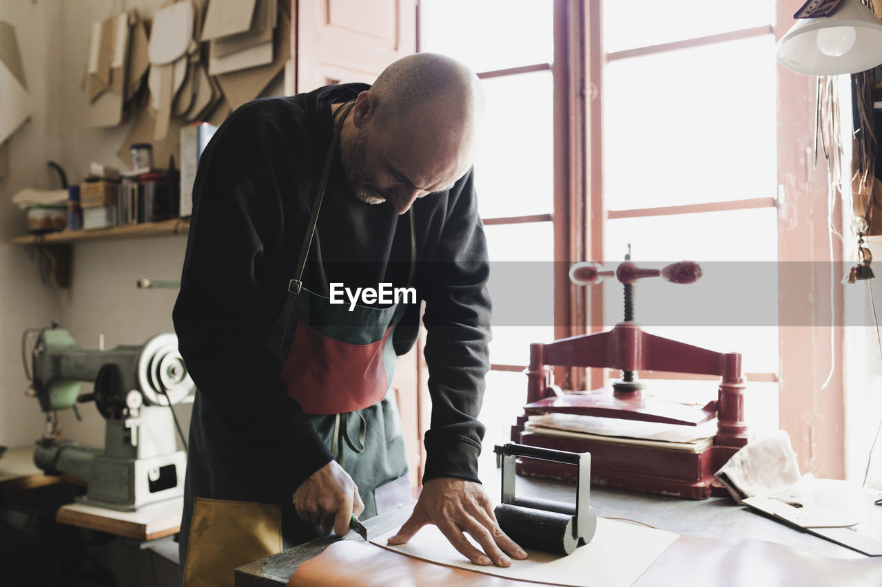 Man cutting textile in atelier