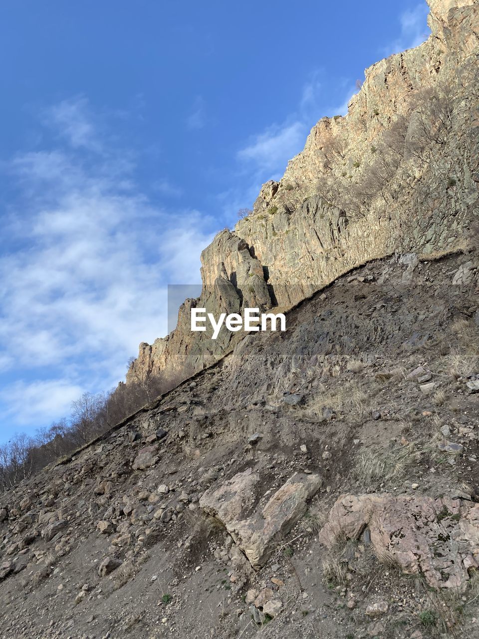 LOW ANGLE VIEW OF ROCK FORMATION ON MOUNTAIN AGAINST SKY