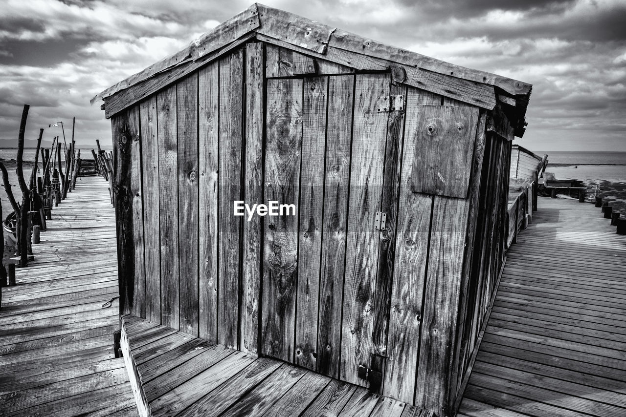 WOODEN POSTS ON FOOTPATH BY BUILDING