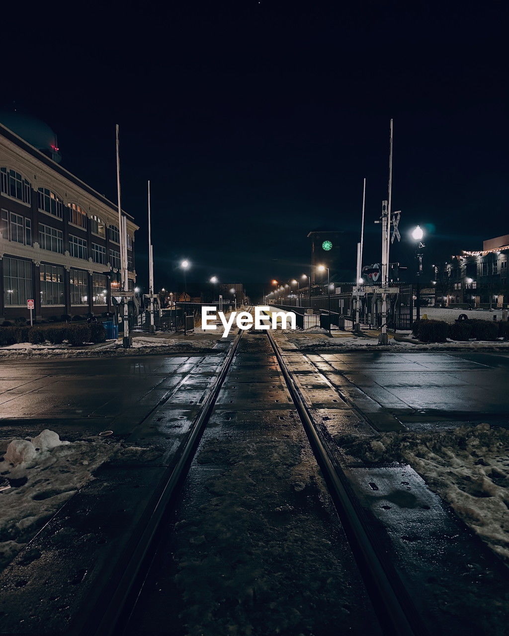 night, darkness, architecture, transportation, illuminated, evening, light, city, built structure, rail transportation, building exterior, street, cityscape, railroad track, dusk, track, reflection, mode of transportation, sky, street light, urban area, no people, nature, outdoors, lighting, road, travel destinations, lighting equipment
