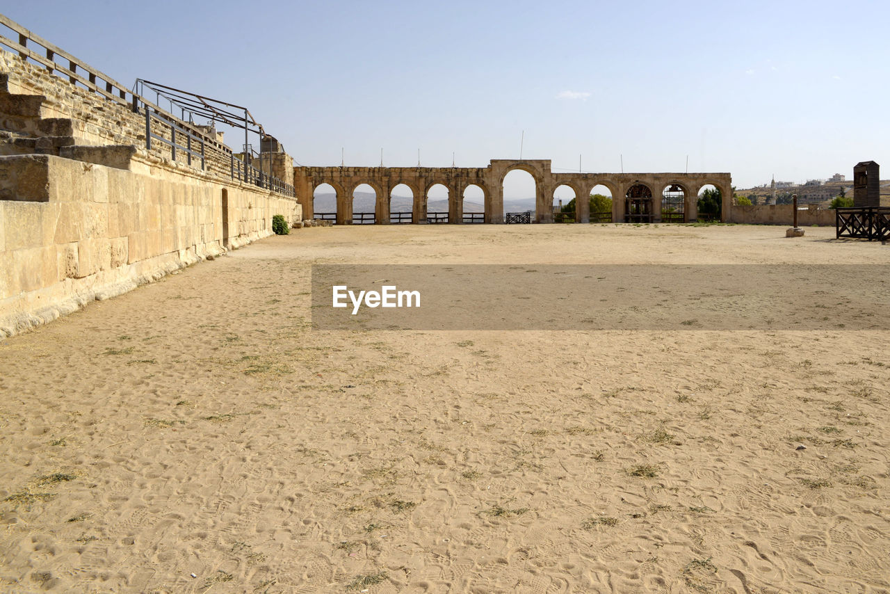 architecture, built structure, sky, bridge, nature, history, walkway, clear sky, the past, travel destinations, day, no people, land, water, arch, outdoors, building exterior, transportation, sand, travel, sunny, ancient history, sunlight, city, copy space