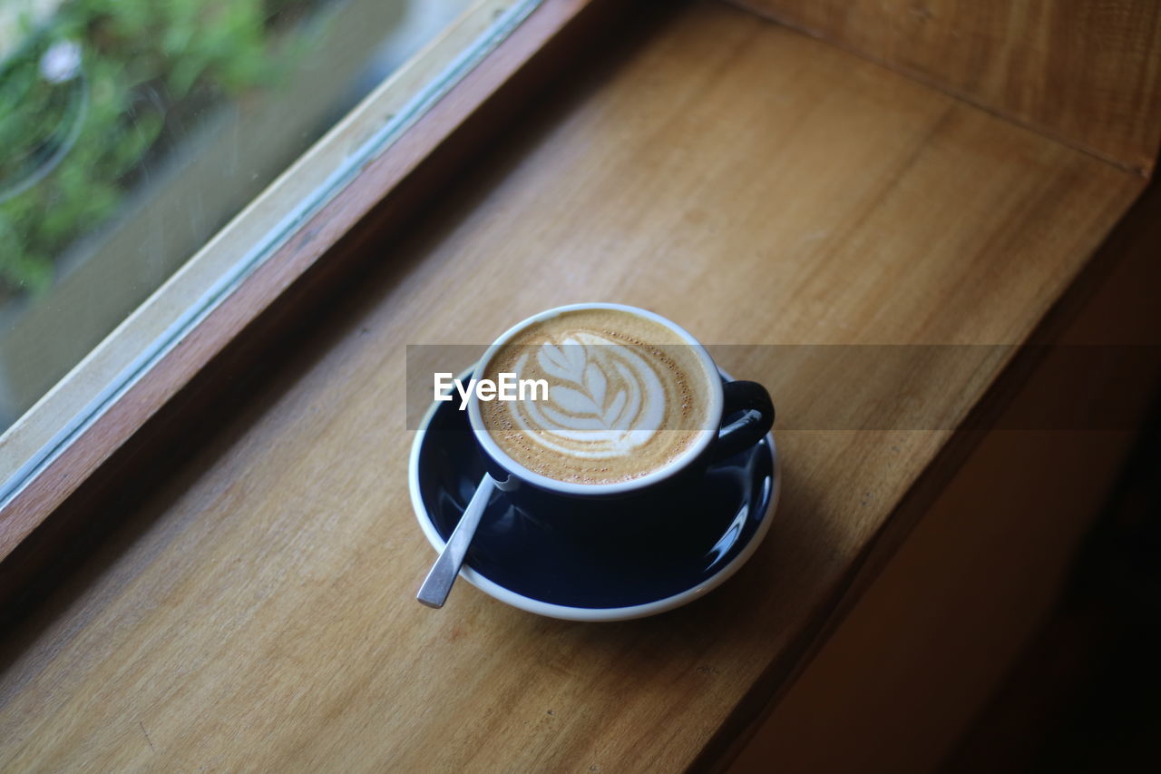 coffee, drink, coffee cup, mug, cup, refreshment, food and drink, cappuccino, hot drink, frothy drink, table, crockery, saucer, froth art, still life, wood, indoors, latte, high angle view, no people, cafe, freshness, food