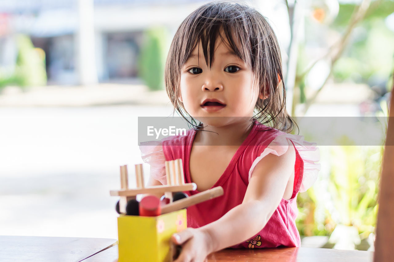 Portrait of baby girl playing with toy at home