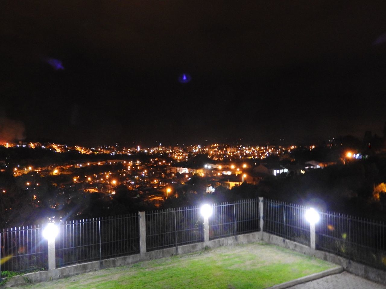 VIEW OF ILLUMINATED CITYSCAPE AT NIGHT