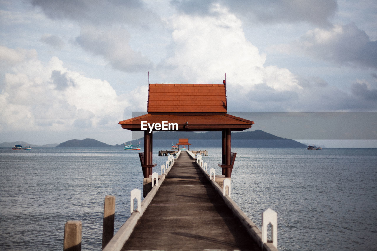 PIER OVER SEA AGAINST SKY AND BUILDINGS