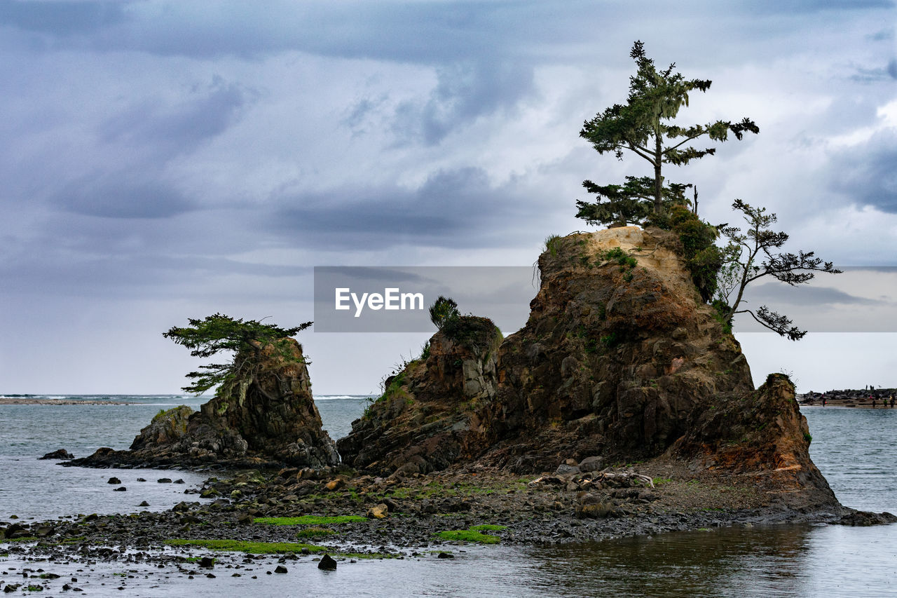 Rock formation on beach against sky