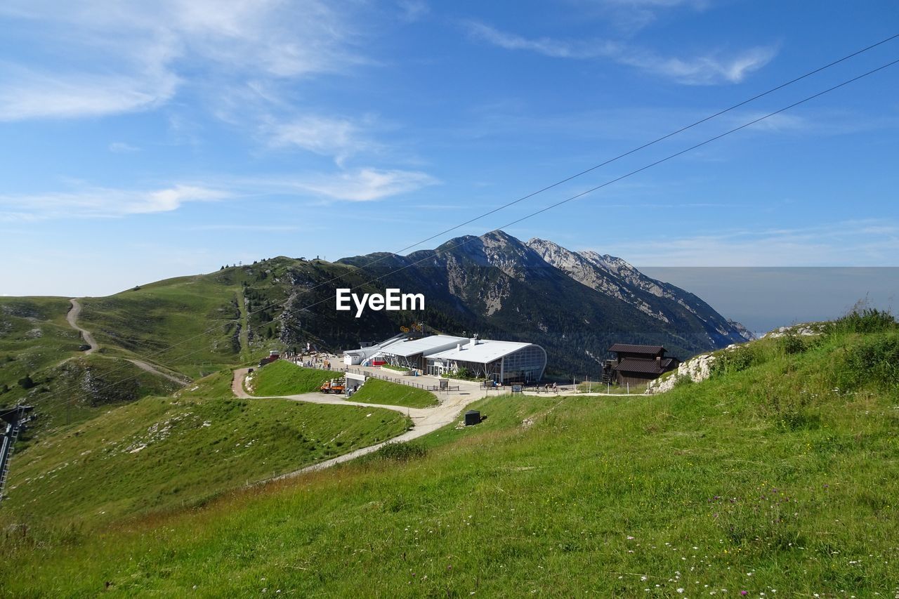 Houses on field by mountain against sky