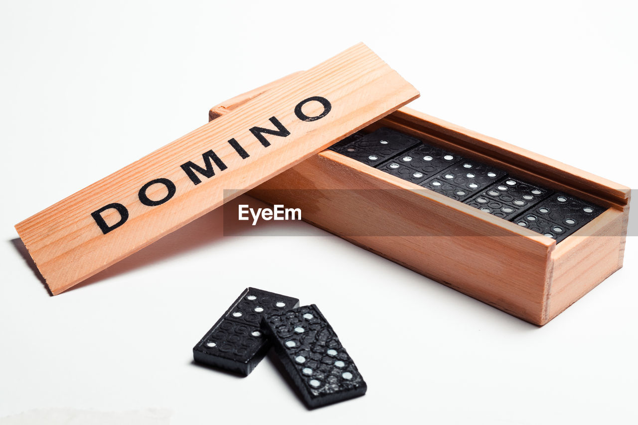 High angle view of dominoes in container against white background
