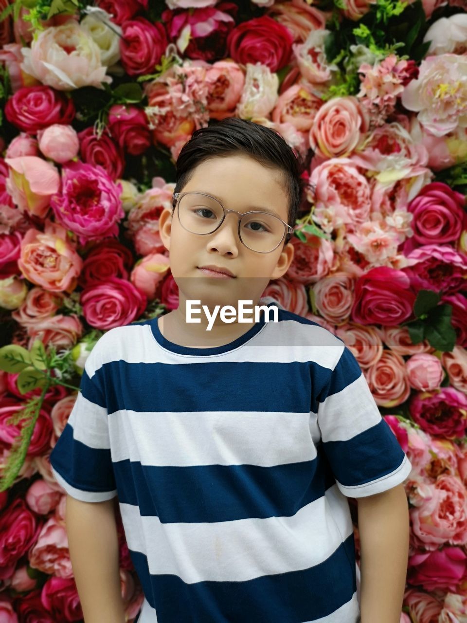 Portrait of smiling boy against roses