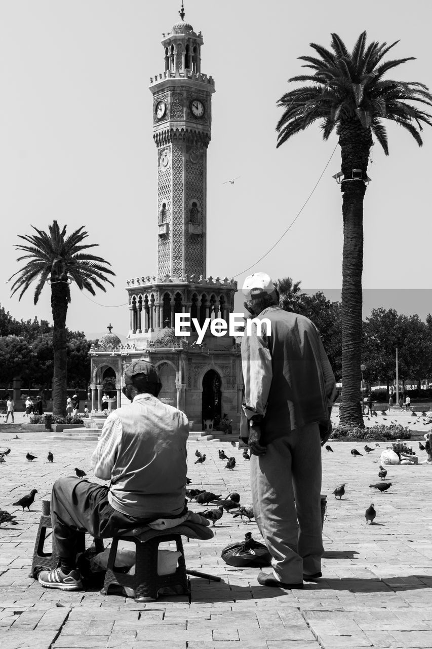 PEOPLE SITTING IN FRONT OF A BUILDING