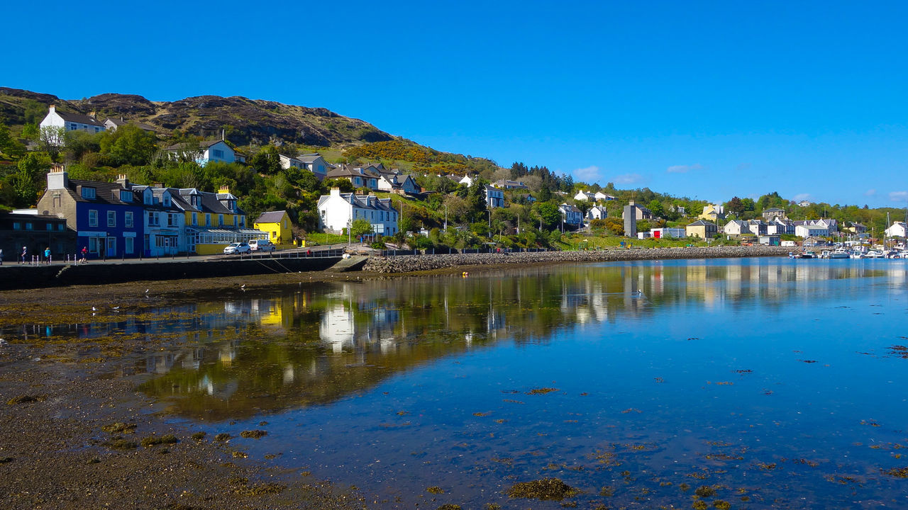 HOUSES BY LAKE AGAINST BLUE SKY