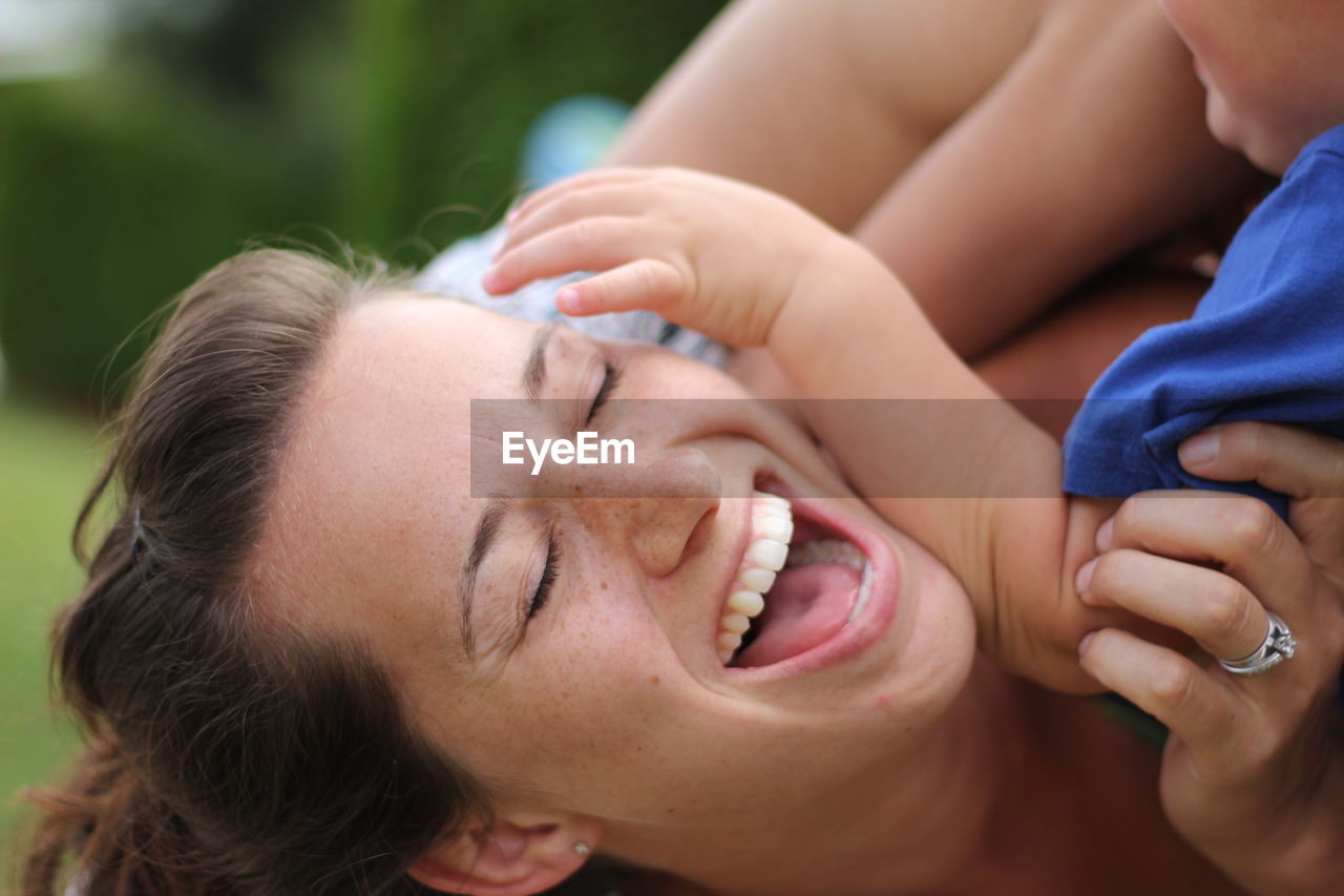 Close-up of happy mother playing with son