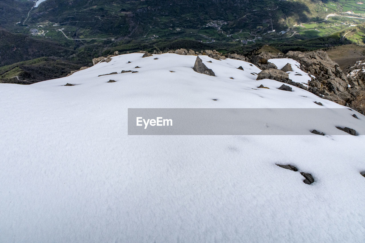 HIGH ANGLE VIEW OF SNOW COVERED LAND ON MOUNTAIN