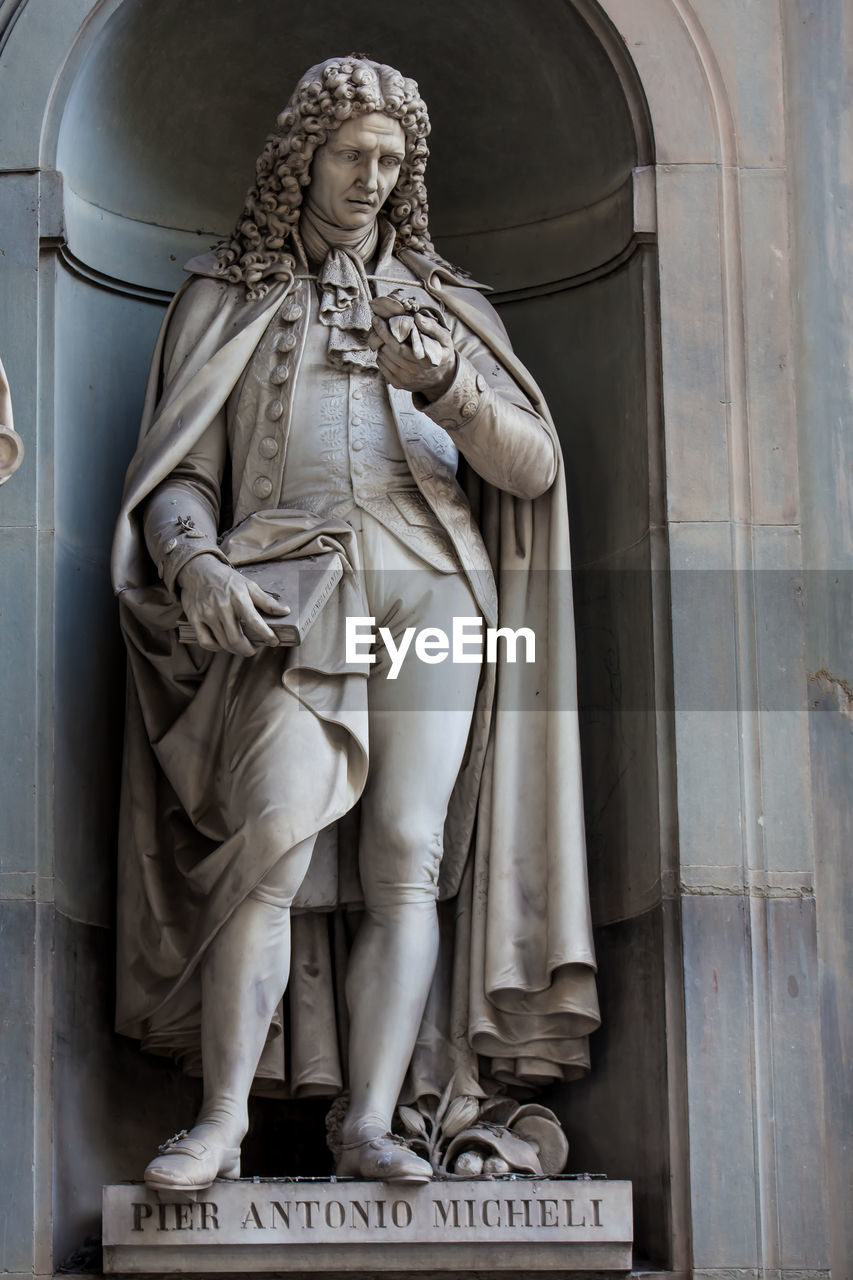 LOW ANGLE VIEW OF STATUE OF STATUES AGAINST BUILDING